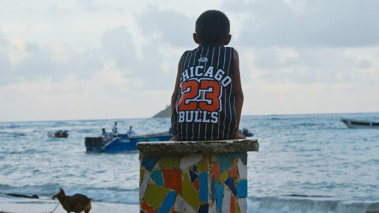 a child in a Bulls jersey looking at the ocean